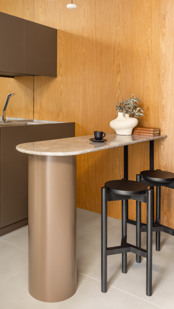 Cozinha planejada Casttini com bancada de pedra, armários suspensos em tom neutro e design focado em ergonomia e funcionalidade essencial