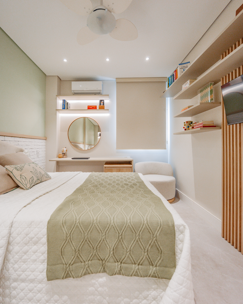 Quarto planejado Casttini com cama de casal, painel ripado amadeirado, prateleiras suspensas com iluminação LED e poltrona de apoio clara